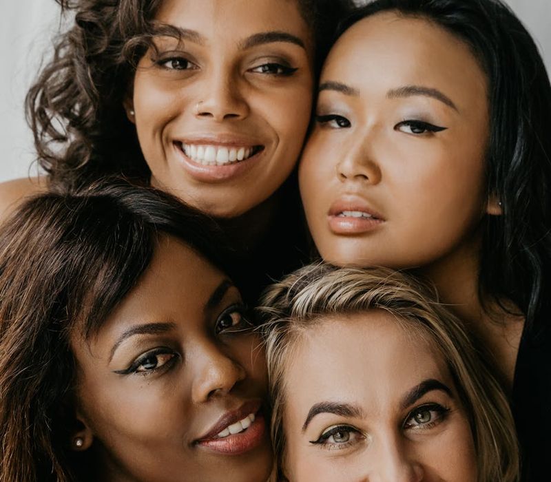 Group of diverse women smiling and supporting each other.